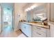 This bathroom has marble countertops, a large mirror and white cabinets at 24103 Pyramid Way, Punta Gorda, FL 33955