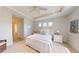 Bright bedroom featuring tray ceilings, light walls, carpet, and large windows at 24103 Pyramid Way, Punta Gorda, FL 33955