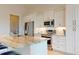 Modern kitchen with an island, pendant lighting, stainless steel appliances, and stone countertops at 24103 Pyramid Way, Punta Gorda, FL 33955