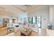 Bright open living area with white furniture, a chef's kitchen and large windows overlooking the pool at 24103 Pyramid Way, Punta Gorda, FL 33955