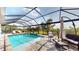 Screened-in pool area with clear blue water, poolside furniture and green landscaping at 24103 Pyramid Way, Punta Gorda, FL 33955
