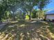 Spacious fenced backyard featuring mature trees offering plenty of shade on a sunny day at 243 Harbor Blvd, Port Charlotte, FL 33954