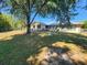 Expansive backyard featuring a metal roofed home, mature trees, and partial fence at 243 Harbor Blvd, Port Charlotte, FL 33954