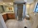 Primary bathroom featuring dual vanity sinks, granite countertops, tiled floors, and a glass shower at 243 Harbor Blvd, Port Charlotte, FL 33954