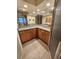 Bathroom features a dual sink vanity with granite countertops, wood cabinets and ample lighting at 243 Harbor Blvd, Port Charlotte, FL 33954
