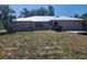 Single Gathering home featuring a metal roof, lush landscaping, and an attached two car garage at 243 Harbor Blvd, Port Charlotte, FL 33954