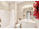 Well-lit bathroom with decorative flowers and a bathtub shower combination, providing a clean and functional space at 2508 Magnolia Cir, North Port, FL 34289