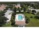 Community pool with lounge chairs, umbrellas, lush landscaping, and clear blue water beckons relaxation at 2508 Magnolia Cir, North Port, FL 34289