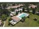 Aerial view of a community pool with clear blue water, surrounded by lush landscaping and comfortable lounge chairs at 2508 Magnolia Cir, North Port, FL 34289