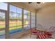 A sunroom provides views of the canal through screened windows and features a table with chairs at 2508 Magnolia Cir, North Port, FL 34289