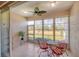 This sunroom features tile floors, a ceiling fan, and large windows overlooking a lush landscape at 2508 Magnolia Cir, North Port, FL 34289