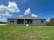 Exterior backyard view, showcasing a spacious green lawn, a patio, and scenic sky at 25156 Rosamond Ct, Punta Gorda, FL 33983