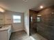 Bathroom featuring walk-in shower with dark tile and granite counters and wood-look floors at 25156 Rosamond Ct, Punta Gorda, FL 33983