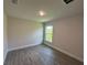 Bedroom with wood-look tile floors and a window that provides natural light at 25156 Rosamond Ct, Punta Gorda, FL 33983