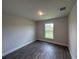 Bedroom with wood-look floors and a window offering a canal view at 25156 Rosamond Ct, Punta Gorda, FL 33983