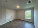 Bright bedroom features wood-look floors, double door closet, and a sunlit window at 25156 Rosamond Ct, Punta Gorda, FL 33983