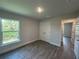 Bright bedroom with wood-look tile flooring, a double door closet, and a sunlit window at 25156 Rosamond Ct, Punta Gorda, FL 33983