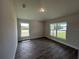 Comfortable bedroom featuring wood-look tile flooring and two windows for natural light at 25156 Rosamond Ct, Punta Gorda, FL 33983