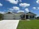 Charming single-story home featuring a three car garage, well-manicured lawn, and beautiful landscaping at 25156 Rosamond Ct, Punta Gorda, FL 33983