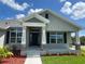 Inviting front porch with decorative columns, a black front door, and professionally landscaped yard at 25156 Rosamond Ct, Punta Gorda, FL 33983