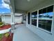 View from the front porch showing stone columns, large windows, and attractive landscaping at 25156 Rosamond Ct, Punta Gorda, FL 33983