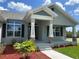 Welcoming front porch with stone accents, professionally landscaped yard, and black window shutters at 25156 Rosamond Ct, Punta Gorda, FL 33983