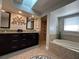 Bright bathroom featuring a soaking tub, a shower and double vanities under a skylight at 25263 Padre Ln, Punta Gorda, FL 33983
