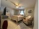 Bright bedroom featuring a ceiling fan, tile floors, and a cozy chair with natural lighting at 25263 Padre Ln, Punta Gorda, FL 33983