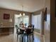 Dining room with dining table and chairs, window, chandelier, and tile flooring at 25263 Padre Ln, Punta Gorda, FL 33983