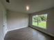 Bright bedroom featuring hardwood floors and a large window overlooking a green yard at 26209 Madras Ct, Punta Gorda, FL 33983