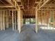 Interior view of home construction showing exposed wood framing and concrete floors at 26209 Madras Ct, Punta Gorda, FL 33983