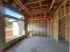 Interior view of unfinished room showing exposed framing and concrete floors in a new home construction project at 26209 Madras Ct, Punta Gorda, FL 33983