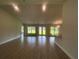 Spacious living room with lots of natural light, featuring wood-look tile flooring and neutral walls at 26209 Madras Ct, Punta Gorda, FL 33983