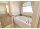 Bathroom featuring a soaking tub with tiled backsplash, curtains, and fixtures at 27854 Arrowhead Cir, Punta Gorda, FL 33982