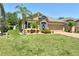 Charming single-story home featuring a stone facade, manicured lawn, and lush landscaping at 27854 Arrowhead Cir, Punta Gorda, FL 33982
