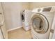 This laundry room features modern, front-load Samsung washer and dryer units over tan tile flooring at 27854 Arrowhead Cir, Punta Gorda, FL 33982