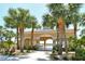 Pool pavilion entrance, framed by swaying palm trees and tropical vegetation. The perfect community retreat at 27854 Arrowhead Cir, Punta Gorda, FL 33982
