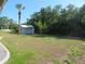 Spacious backyard with storage shed, green lawn, and scattered trees at 296 Milford St, Port Charlotte, FL 33953