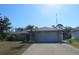 Charming single-story home featuring a well-maintained lawn and a two-car garage at 296 Milford St, Port Charlotte, FL 33953