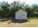 Outdoor storage shed with door and window, set amid trees and foliage at 296 Milford St, Port Charlotte, FL 33953
