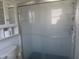 Bathroom with shower featuring glass doors, a showerhead, and white tile at 296 Milford St, Port Charlotte, FL 33953