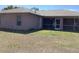 Rear view of the home's exterior, showcasing a screened-in patio area and the backyard at 3293 Cincinnati St, North Port, FL 34286