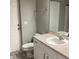 Bathroom showcasing vanity with sink and white cabinets next to toilet and rear exit at 3293 Cincinnati St, North Port, FL 34286