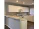 Functional kitchen with white cabinetry, breakfast bar, and ample countertop space at 3293 Cincinnati St, North Port, FL 34286