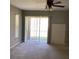 Neutral living area with a sliding glass door and ceiling fan providing natural light and comfort at 3293 Cincinnati St, North Port, FL 34286