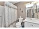 Neutral bathroom featuring a white vanity, toilet, and a shower with decorative curtain at 3300 Loveland Blvd # 2801, Punta Gorda, FL 33980
