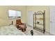 Bedroom with day bed, recliner and shelves, featuring tiled floors and a light-colored wall at 3300 Loveland Blvd # 2801, Punta Gorda, FL 33980