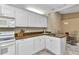This kitchen features white cabinetry, modern appliances, and a view to the dining area at 3300 Loveland Blvd # 2801, Punta Gorda, FL 33980