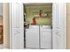 A laundry room with a washer, dryer, and shelving for storage at 3300 Loveland Blvd # 2801, Punta Gorda, FL 33980