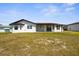 A white house stands on a grassy lot beneath a blue sky at 3315 Elkcam Blvd, Port Charlotte, FL 33952